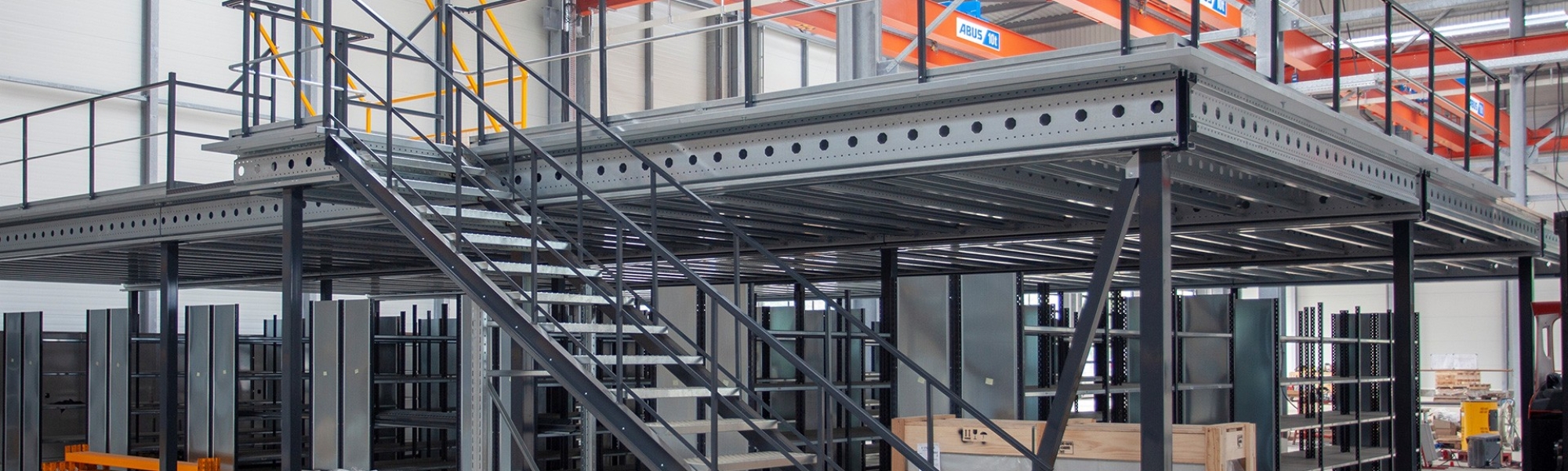 Mezzanine métallique à niveau uni avec escalier et barrière écluse au sein d'un entrepôt
											