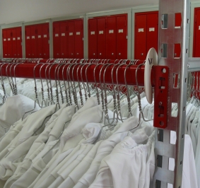 Blouses blanches stockées sur des rayonnages Prorack+ dans un vestiaire collectif 
			