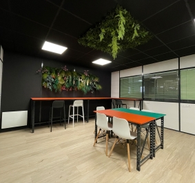 Salle de pause aménagée avec des cloisons de bureau incluant des murs et plafonds végétaux
			