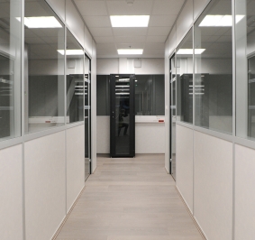 Couloir avec des cloisons de bureaux vitrées au sein d’une entreprise
			