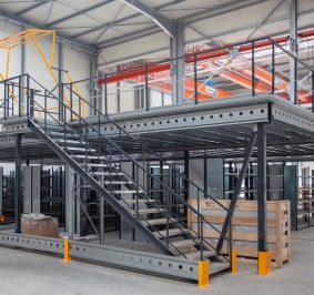 Mezzanine métallique à niveau uni avec escalier et barrière écluse au sein d'un entrepôt
			
