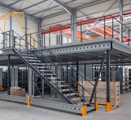 Plateforme de stockage mezzanine métallique à niveau uni avec escalier et barrière écluse au sein d'un entrepôt
                