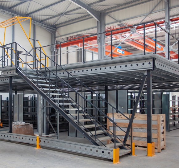 Mezzanine métallique à niveau uni avec escalier et barrière écluse au sein d&#039;un entrepôt
						